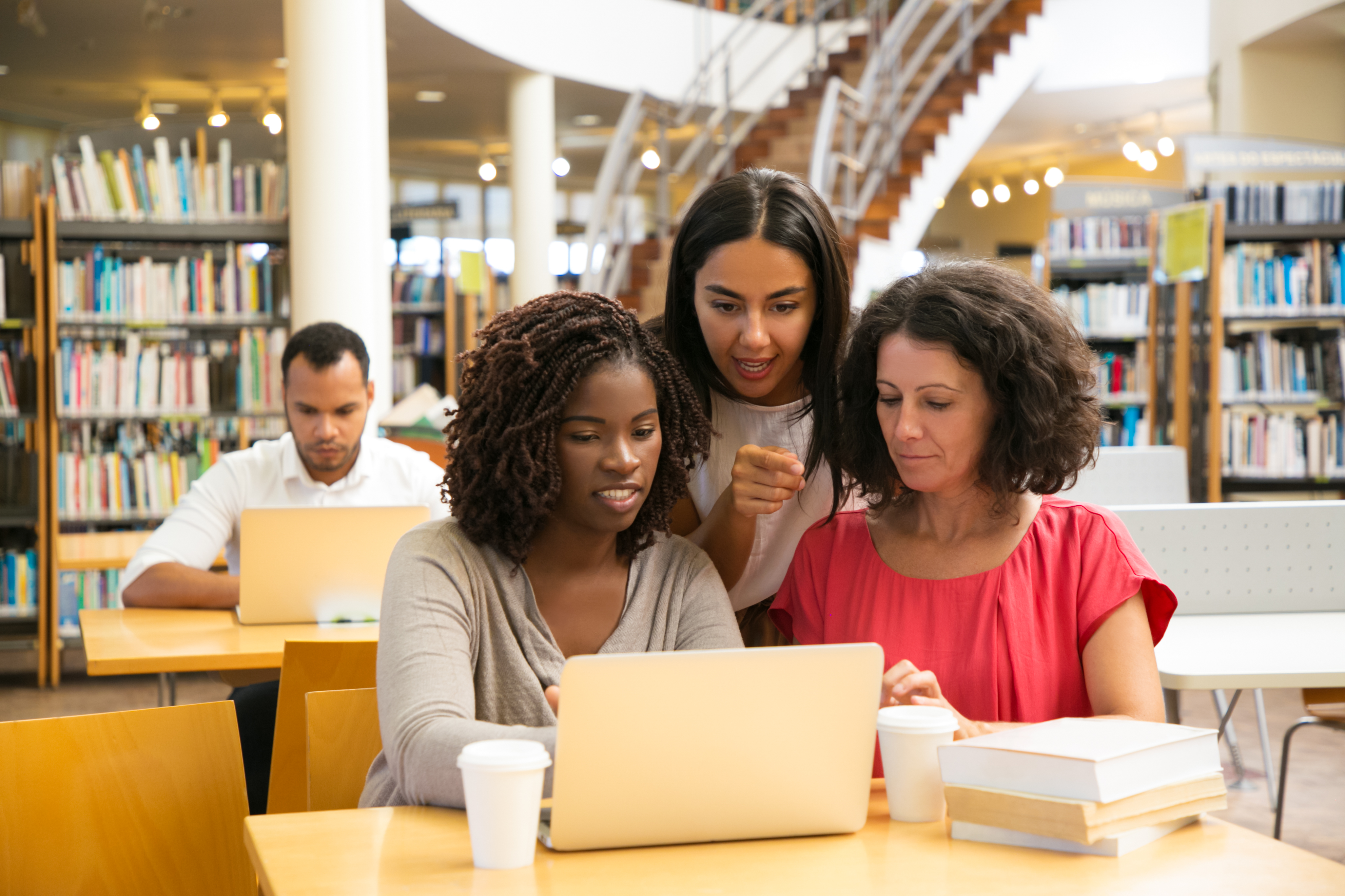 smiling-women-working-with-laptop-public-library